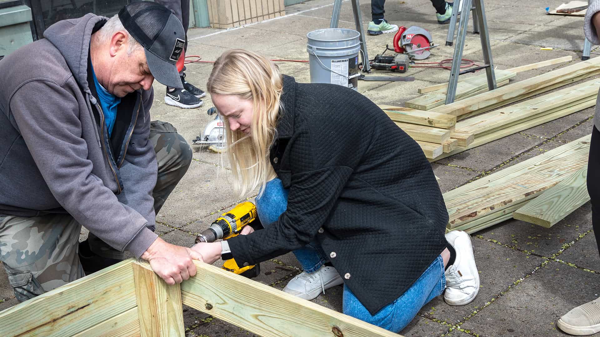 Volunteers constructing plant boxes outside the Ministry Hub doors